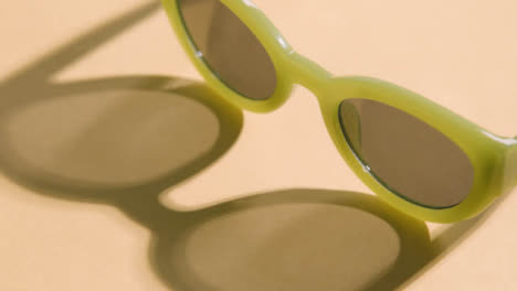 Sommerferienkonzept-Der-Sonnenbrille,-Die-Auf-Gelbem-Hintergrund-Rotiert