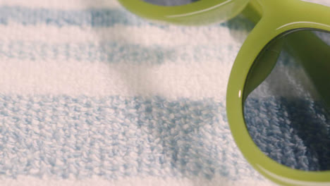 Summer-Holiday-Vacation-Concept-Of-Green-Sunglasses-On-Beach-Towel-1