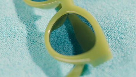 Close-Up-Summer-Holiday-Concept-Of-Green-Sunglasses-On-Beach-Towel-1