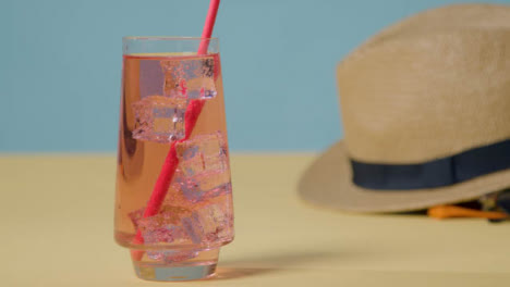 Summer-Holiday-Concept-Of-Cold-Drink-With-Sun-Hat-On-Beach-Towel
