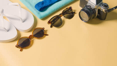 Sommerferienkonzept-Der-Sonnenbrillen-badetuchkamera-Auf-Gelbem-Hintergrund