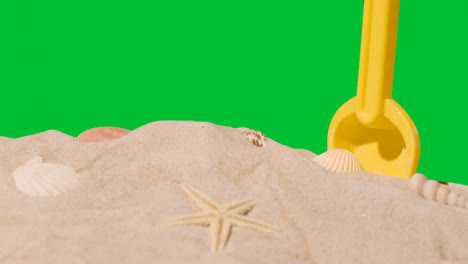 Summer-Holiday-Concept-With-Child's-Plastic-Spade-On-Sandy-Beach-Against-Green-Screen-1