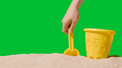 Summer-Holiday-Concept-With-Child's-Bucket-Spade-On-Sandy-Beach-Against-Green-Screen-4