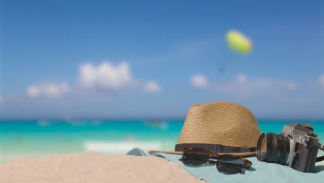Sommerferienkonzept-Der-Kamera-Sonnenhut-Sonnenbrille-Strandtuch-Auf-Sand-Gegen-Meer