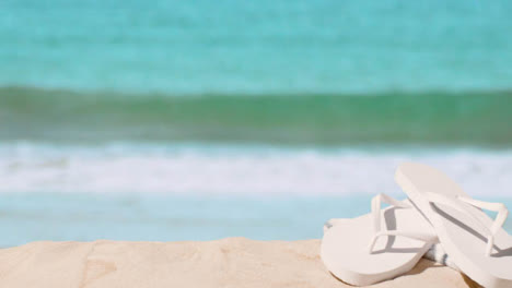 Summer-Holiday-Concept-Of-Flip-Flops-On-Sand-Against-Sea-Background