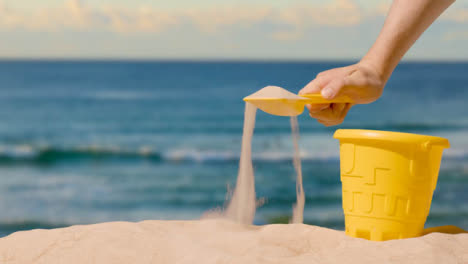 Summer-Holiday-Concept-Of-Digging-With-Child's-Bucket-Spade-On-Sandy-Beach-Against-Sea-Background-2