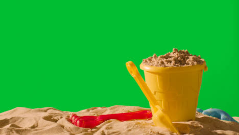 Summer-Holiday-Concept-With-Child's-Bucket-Spade-On-Sandy-Beach-Against-Green-Screen-1