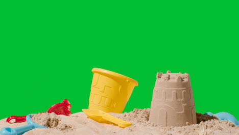 Summer-Holiday-Concept-Making-Sandcastle-On-Sandy-Beach-Against-Green-Screen-4