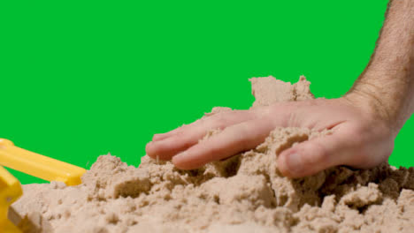 Summer-Holiday-Concept-Smashing-Sandcastle-On-Sandy-Beach-Against-Green-Screen-6