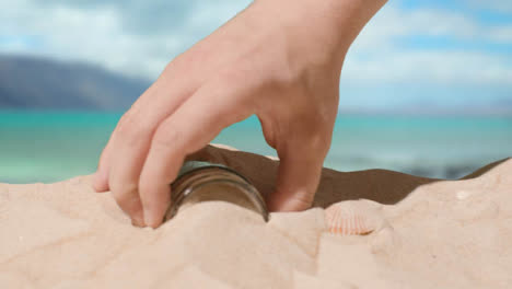 Pollution-Concept-With-Hand-Picking-Up-Bottles-And-Rubbish-On-Beach-Against-Sea-Background-1