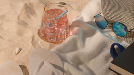 Summer-Holiday-Concept-Of-Cold-Drink-Sunglasses-Beach-Towel-Flip-Flops-Hat-Book-On-Sand-2
