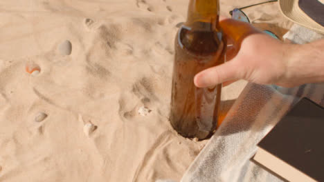 Summer-Holiday-Concept-Of-Beer-Bottle-Sunglasses-Beach-Sun-Hat-On-Sand-Background-2