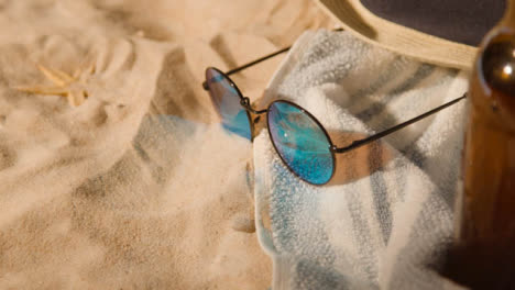 Sommerferienkonzept-Der-Bierflasche-Sonnenbrille-Strandtuch-Sonnenhut-Auf-Sand