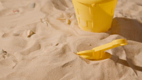 Summer-Holiday-Concept-Of-Children-Bucket-Spade-Toys-Beach-On-Sand-Background-1