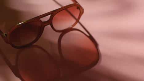 Sommerferienkonzept-Der-Sonnenbrille-Auf-Rosa-Hintergrund-Mit-Baumschattenschatten