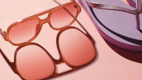 Concepto-De-Vacaciones-De-Verano-De-Gafas-De-Sol-Y-Chanclas-Sobre-Fondo-Rosa