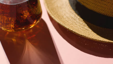 Summer-Holiday-Concept-Of-Sun-Hat-Cold-Drink-On-Pink-Background