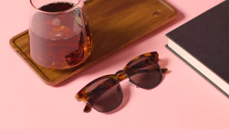 Summer-Holiday-Concept-Of-Sunglasses-Cold-Drink-Book-Tray-On-Pink-Background