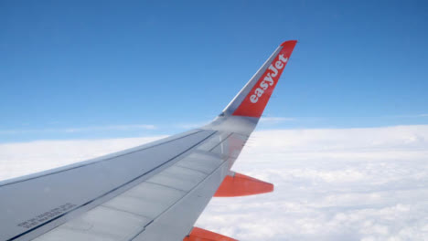 Blick-Vom-Flugzeugfenster-Auf-Blauen-Himmel-Und-Wolken-Auf-Dem-Flug-In-Die-Sommerferien