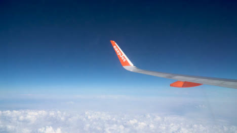 View-From-Plane-Window-Of-Blue-Sky-And-Clouds-On-Flight-To-Summer-Holiday-Vacation-1