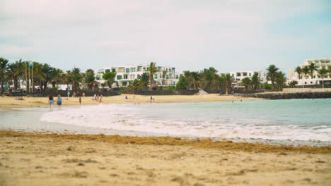 Playa-De-Vacaciones-De-Verano-Junto-Al-Mar-Con-Hotel-En-Segundo-Plano