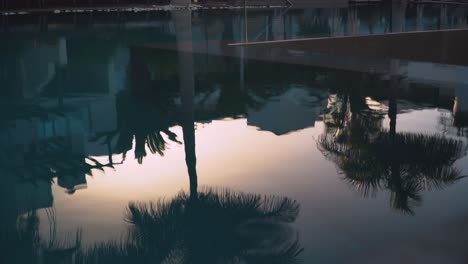 Reflections-In-Water-Of-Empty-Holiday-Hotel-Swimming-Pool-At-Dusk