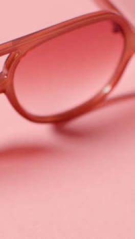 Vertikales-Videosommerferienkonzept-Der-Sonnenbrille-Auf-Rosa-Hintergrund