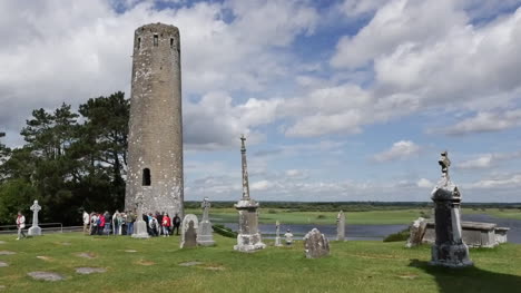 Irland-Clonmacnoise-Ein-Runder-Turm-Und-Eine-Reisegruppe-An-Einer-Hohen-Kreuzpfanne