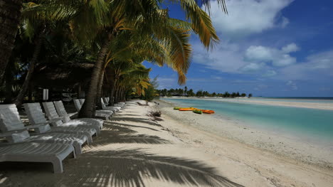 Aitutaki-Stühle-An-Der-Lagune-Mit-Palmen-Und-Schatten