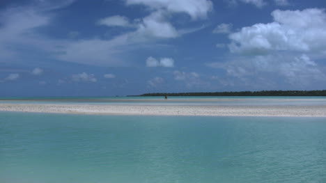 Aitutaki-Couple-In-Distance-On-Sand-Bar-In-Lagoon