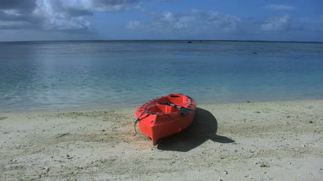 Das-Rote-Kajak-Von-Aitutaki-Liegt-An-Einem-Strand-An-Einer-Lagune