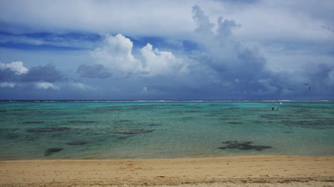 Playa-De-Rarotonga-Y-Nubes-Con-Windsurfista