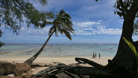 Rarotonga-Three-People-Walk-Along-The-Edge-Of-The-Lagoon