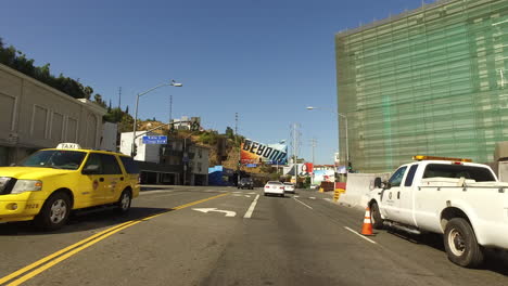 Los-Angeles-Driving-Past-Cars-And-Trucks-And-Through-A-Yellow-Light