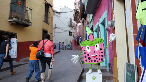 Mexico-Guanajuato-People-Walking-On-Street-With-Pink-Sign