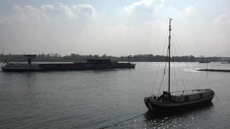 Deutschland-Lastkahn-übergibt-Hinterleuchtetes-Segelboot-Auf-Dem-Rhein