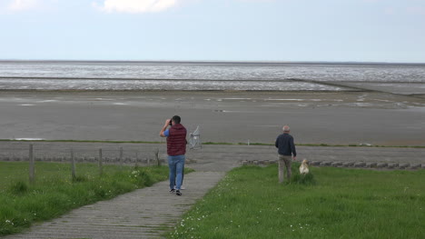 Alemania-Mar-De-Wadden-La-Gente-Camina-Por-El-Dique-Con-El-Perro-Con-Marea-Baja