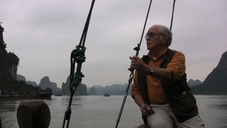 Vietnam-Halong-Bay-man-on-boat-holds-line