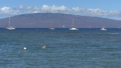 Zooms-on-girl-and-sailboats-in-Hawaii
