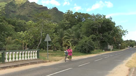 Mujer-Moorea-Empuja-Bicicleta-En-La-Carretera