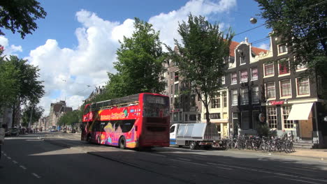 Netherlands-Amsterdam-red-tour-bus-bikes-under-gable