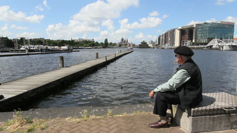 Netherlands-Amsterdam-canal-pier-man-in-beret