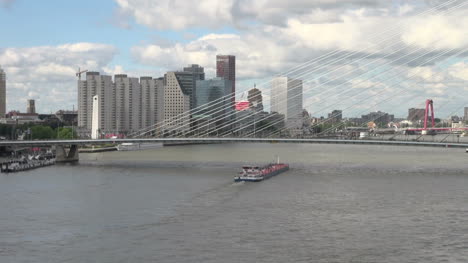 Netherlands-Rotterdam-barge-passes-under-suspension-bridge