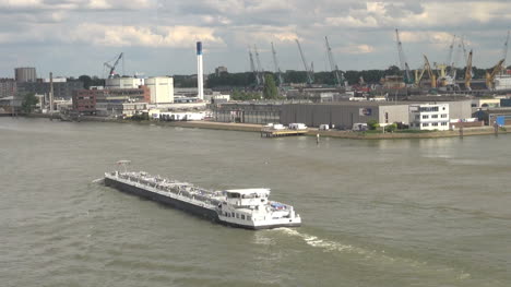 Niederlande-Rotterdam-Lastkahn-Passiert-Industrielle-Uferpromenade