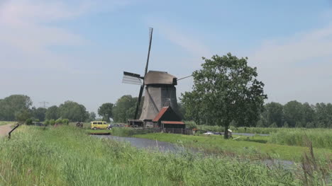 Niederländische-Kinderdijk-Windmühle-In-Der-Nähe-Von-Gelbem-Auto-Und-Rotem-Dach-17