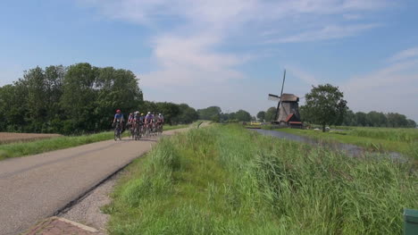 Netherlands-Kinderdijk-group-of-bikes-approach-past-windmill-20