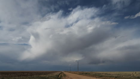 Dunkle-Wolken-Ziehen-Schnell-über-Eine-Unbefestigte-Straße-In-Der-Ebene