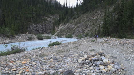 Canada-Alberta-Banff-Bow-Falls-man-hikes-near-stream-10