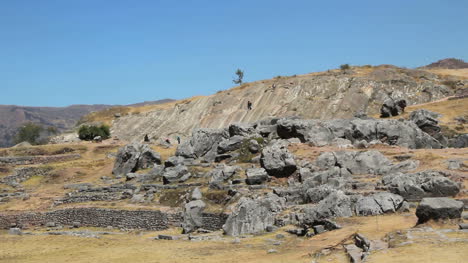 Peru-Sacsayhuaman-Menschen-Rutschen-Auf-Felsen-In-Der-Nähe-Von-Inkaruinen-4