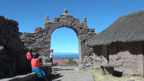 Perú-Taquile-Hombre-Bajo-Arco-De-Piedra-Y-Techo-De-Paja-Casa-2